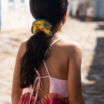 Costas do vestido infantil em linho rosa com amarração e saia em tom cereja.