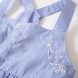 Detalhe do bordado de pássaros do vestido infantil em linho e algodão azul.