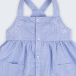 Vestido azul em linho e algodão infantil com pássaros bordados à mão para meninas, visto em detalhe.