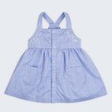 Vista completa de vestido infantil para meninas em linho e algodão azul com botões frontais, bordados de pássaros e bolsos.