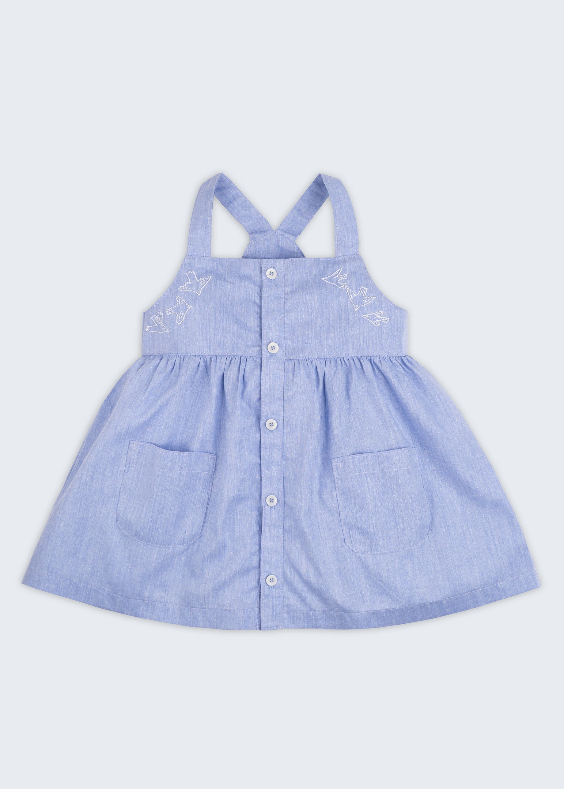 Vista completa de vestido infantil para meninas em linho e algodão azul com botões frontais, bordados de pássaros e bolsos.