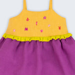 Detalhe do vestido infantil de alcinhas finas em linho roxo e amarelo com detalhe franzido verde limão e bordados à mão de bichinhos do fundo do mar.