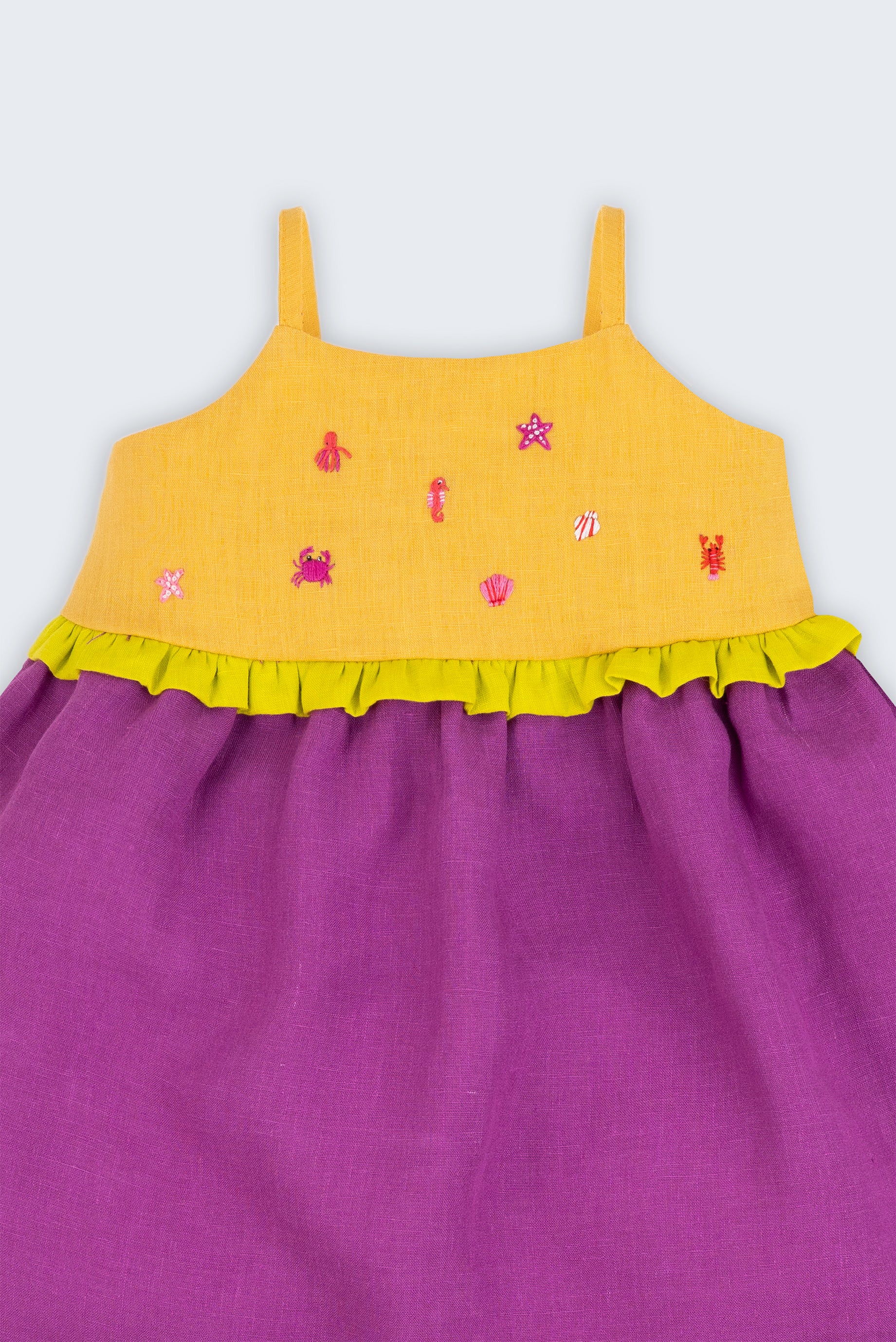 Detalhe do vestido infantil de alcinhas finas em linho roxo e amarelo com detalhe franzido verde limão e bordados à mão de bichinhos do fundo do mar.