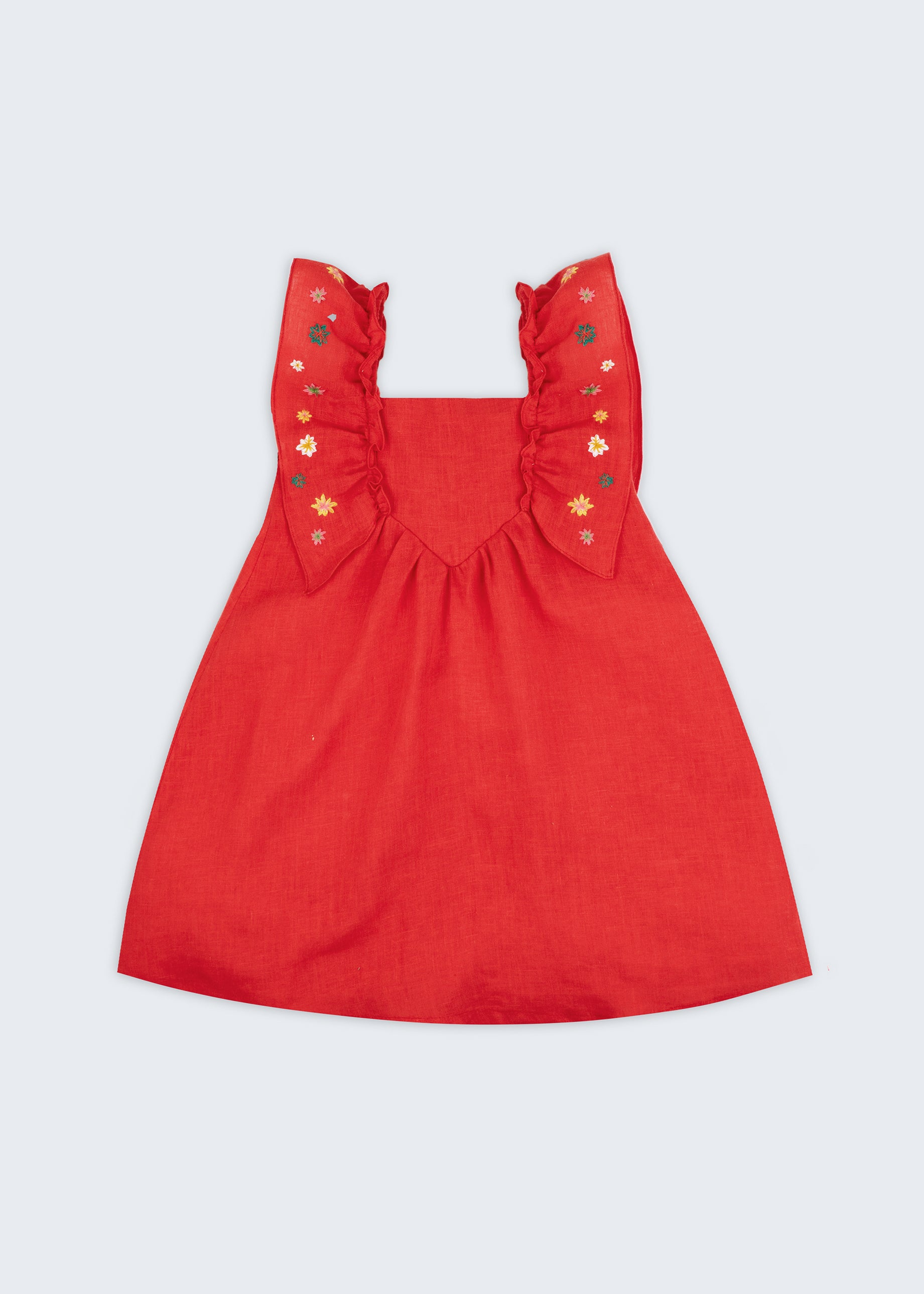 Vestido infantil de menina em linho vermelho com bordado artesanal de estrelas natalinas e babados delicados, visto de frente.