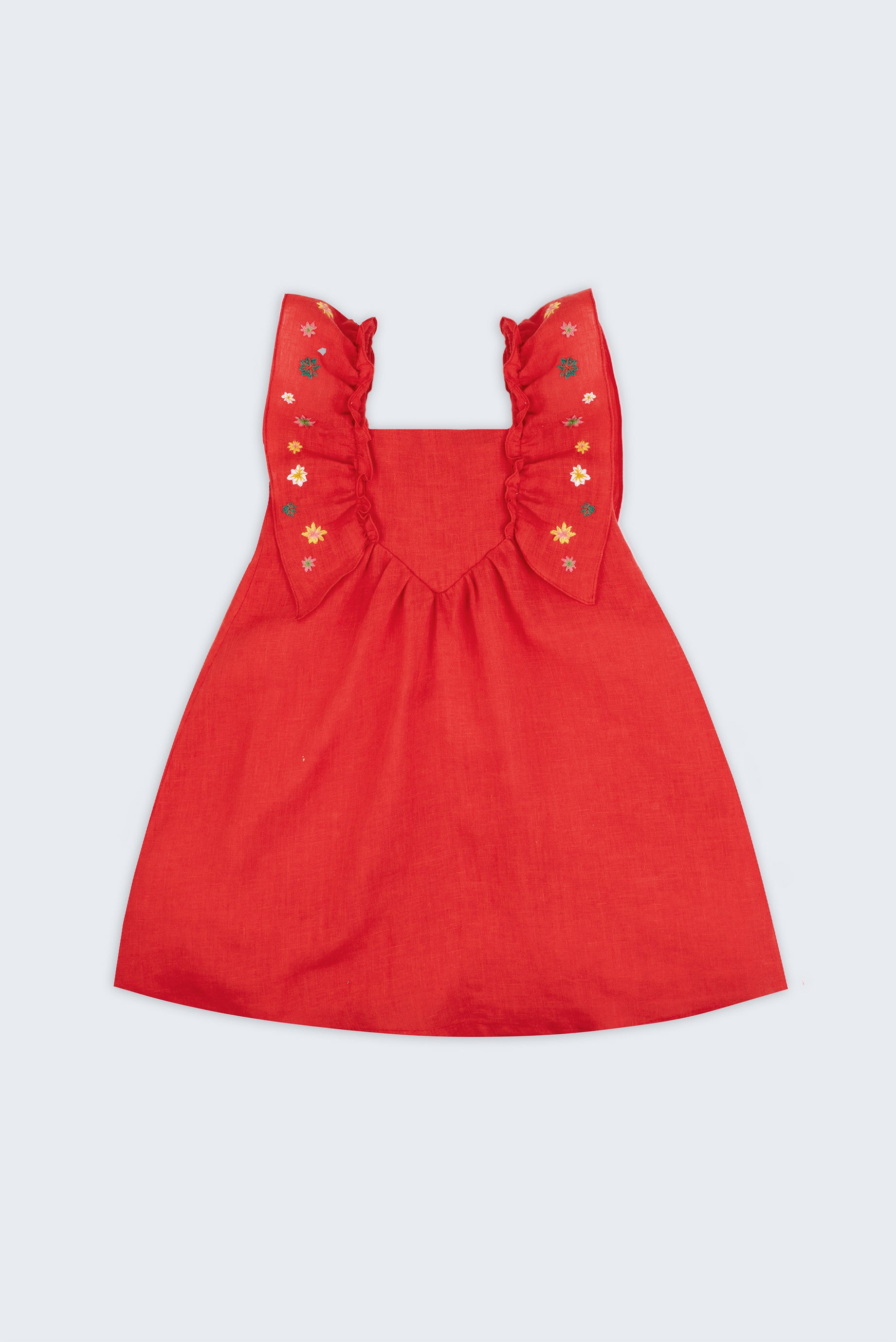 Vestido infantil de menina em linho vermelho com bordado artesanal de estrelas natalinas e babados delicados, visto de frente.