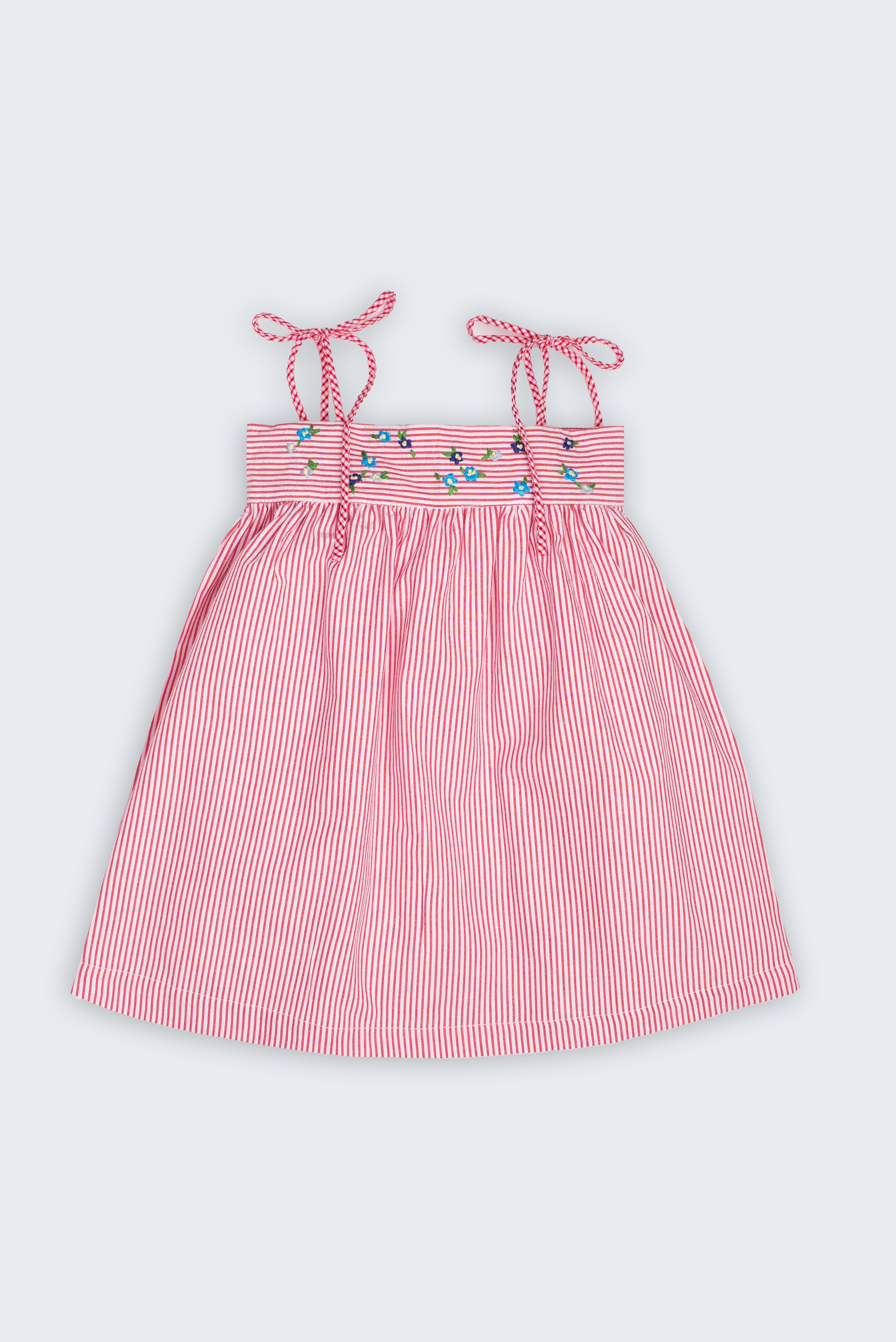 Vestido Flora infantil em algodão anarruga vermelho e branco, com flores bordadas à mão, alças de amarrar e saia franzida.