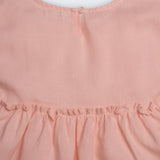 Vestido Pietra em puro linho rosa claro, com mangas e saia com babado, visto de costas em detalhe.