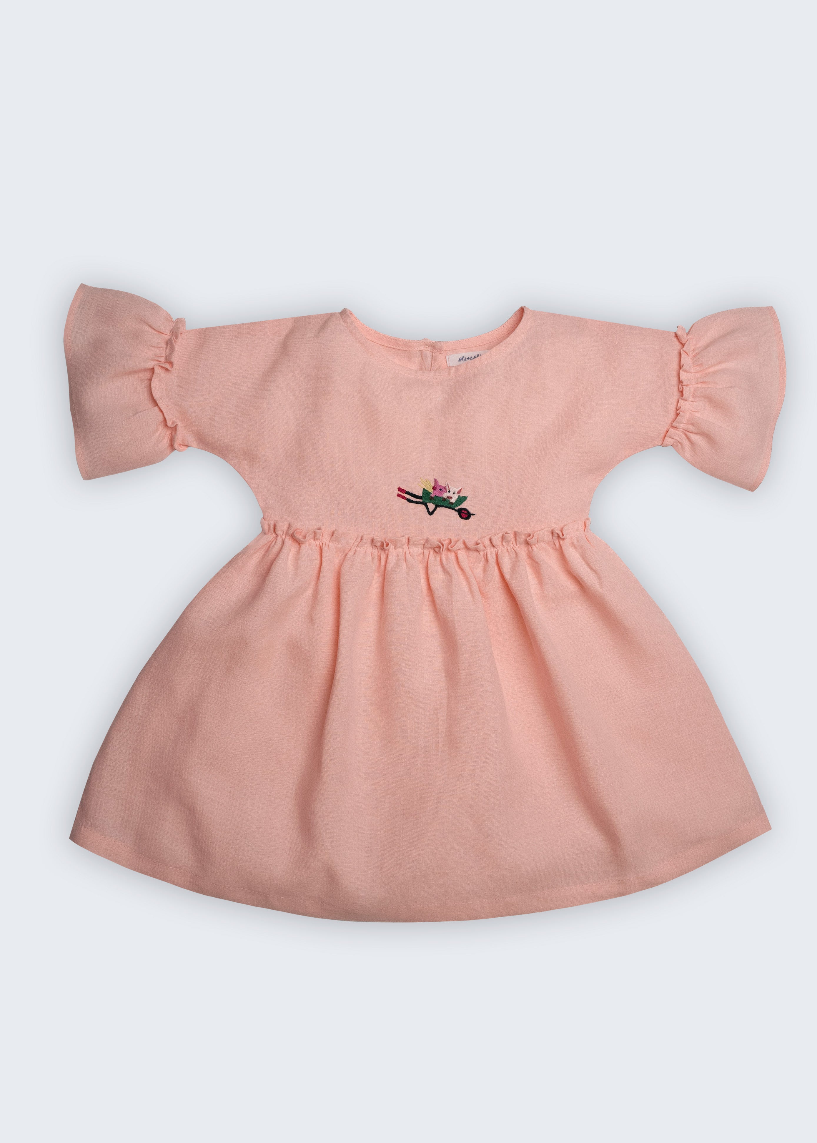 Vestido Pietra em puro linho rosa claro, com mangas e saia com babado e bordado manual de porquinhos, visto de frente.