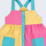 Detalhe do vestido infantil em viscose Ecovero™ e algodão BCI, mostrando alças azuis e contraste de cores.