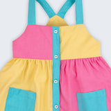 Detalhe do vestido infantil em viscose Ecovero™ e algodão BCI, mostrando alças azuis e contraste de cores.