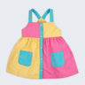 Vestido infantil color block em amarelo, rosa pink e azul turquesa para meninas, com bolsos frontais e alças retas, visto de frente.